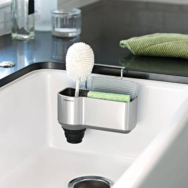 Sink organizer with brush, sponge, and scrub pad neatly stored. Ideal for kitchen organization and efficient cleaning