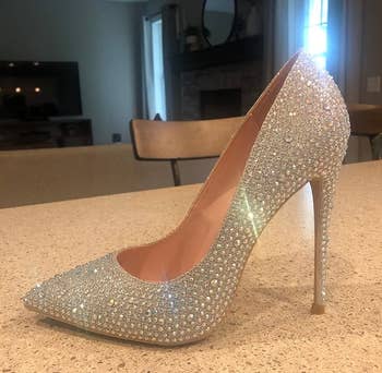 Sparkling high-heeled shoe covered in small rhinestones, displayed on a countertop in a modern living space