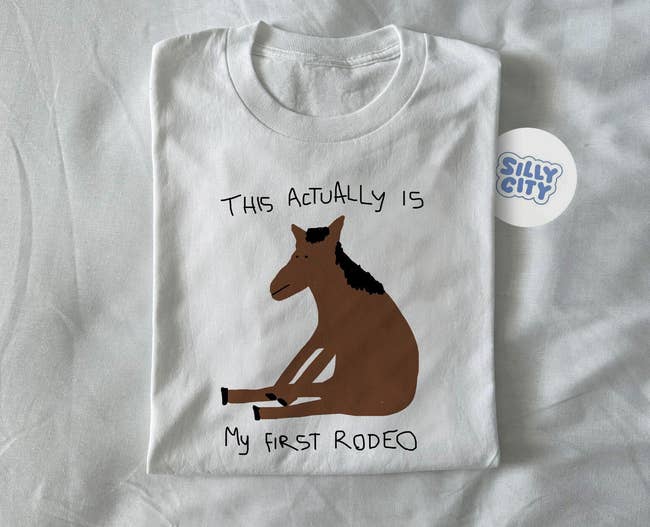 A white shirt with a horse drawn on it that says