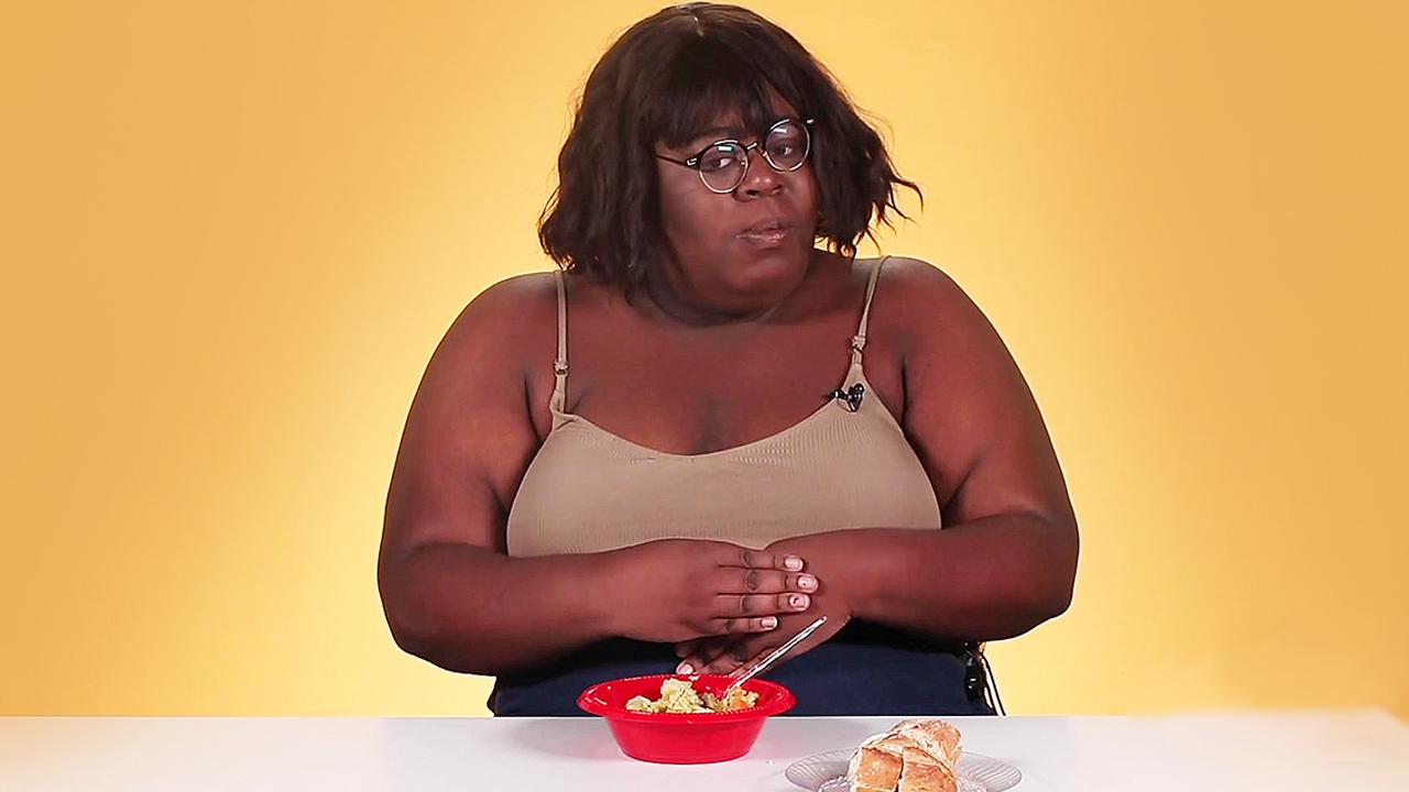 A woman eats Soup Joumou