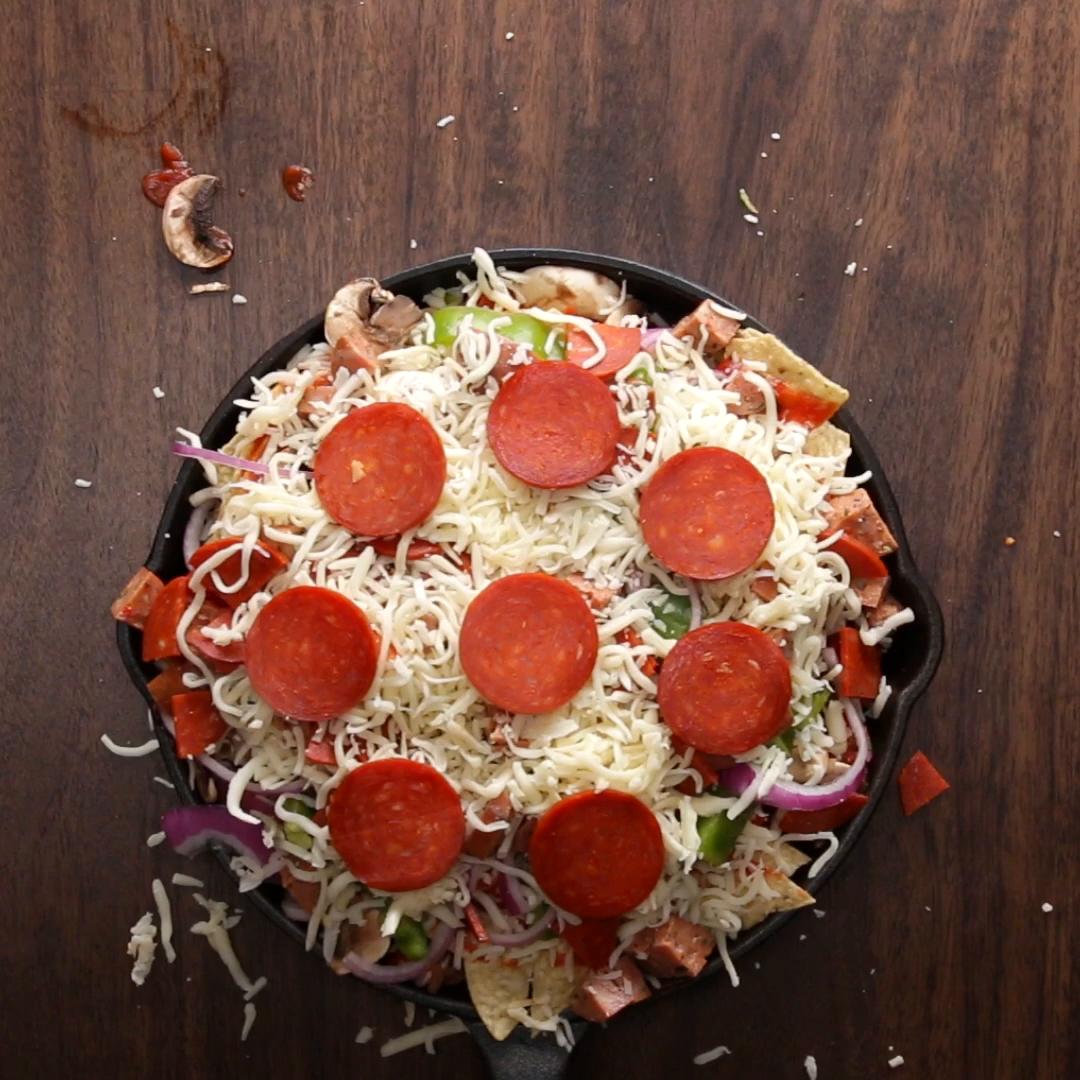 recipes Skillet pizza with pepperoni, mozzarella, mushrooms, and bell peppers on a wooden surface