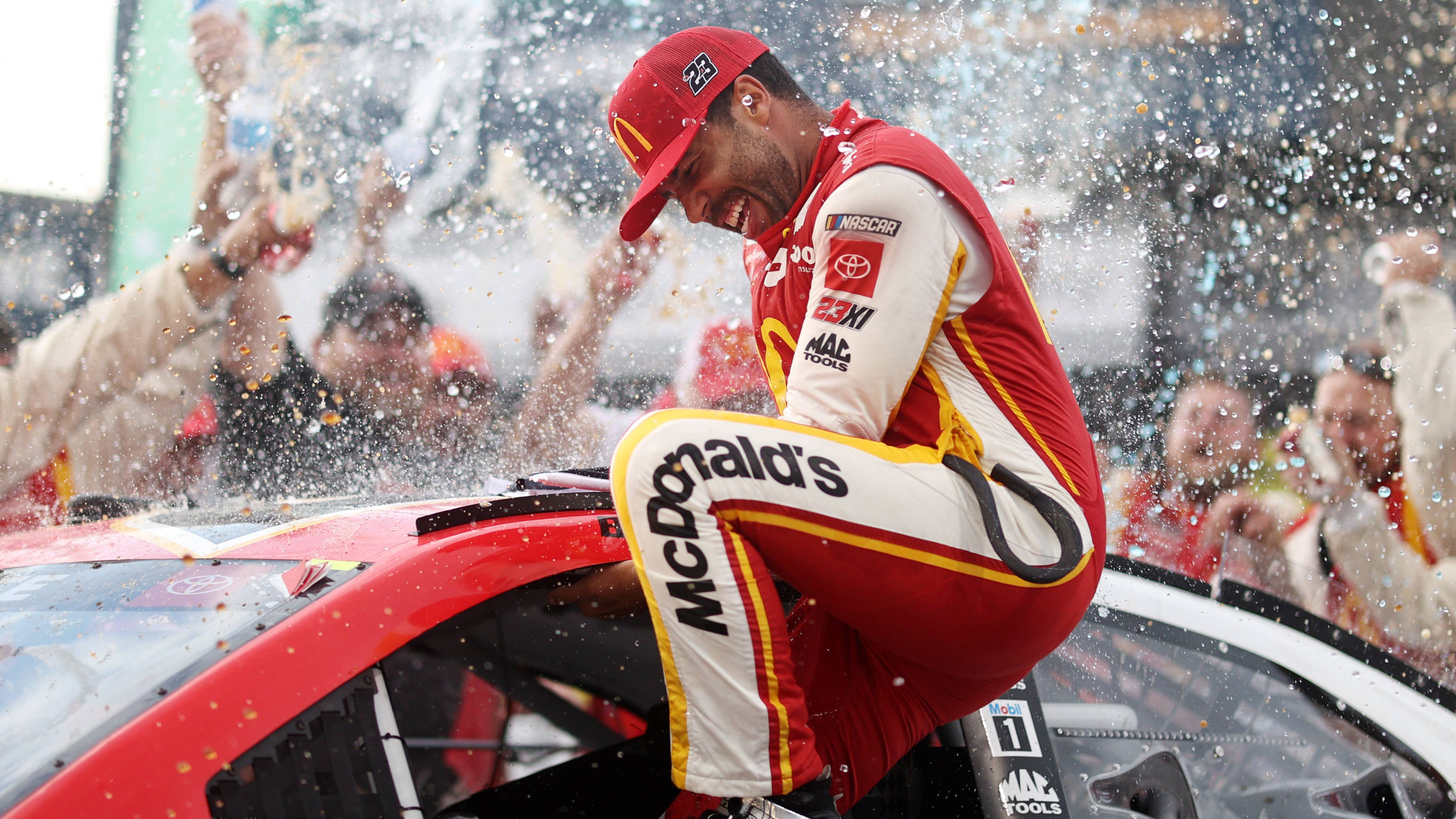 Bubba Wallace exits car while champagne sprays