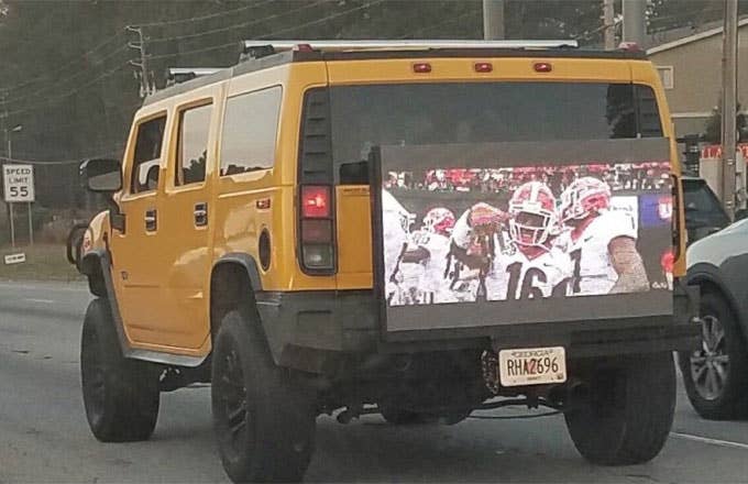 A cocky Georgia fan plays the SEC Championship Game on the back of his Hummer.