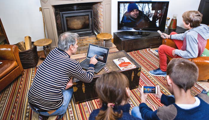 Family in their living room, in front of screens