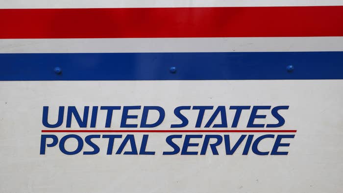 The United States Postal Service (USPS) logo is seen on the side of a truck