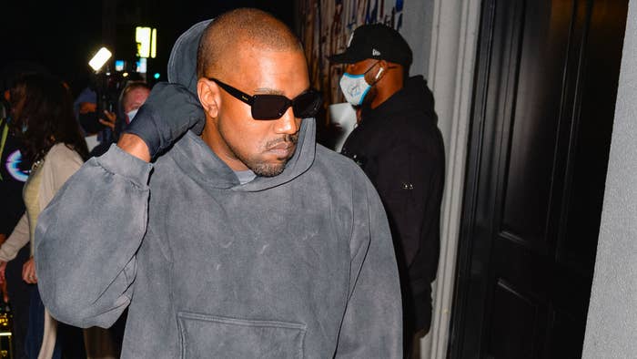 Ye is seen outside in shades and a hoodie