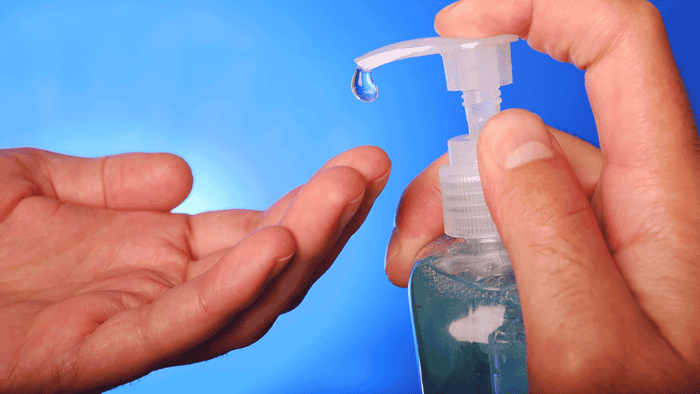 Man squeezes hand sanitizer bottle.