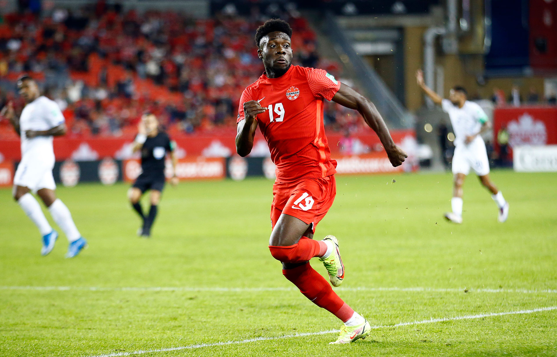 Alphonso Davies #19 of Canada chases the ball during a 2022 World Cup Qualifying