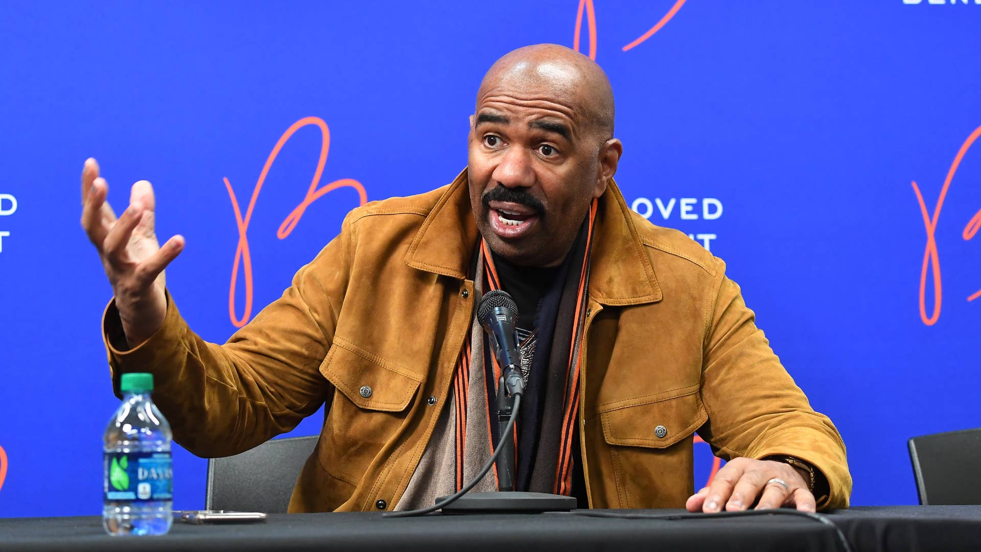 Steve Harvey is pictured speaking with reporters