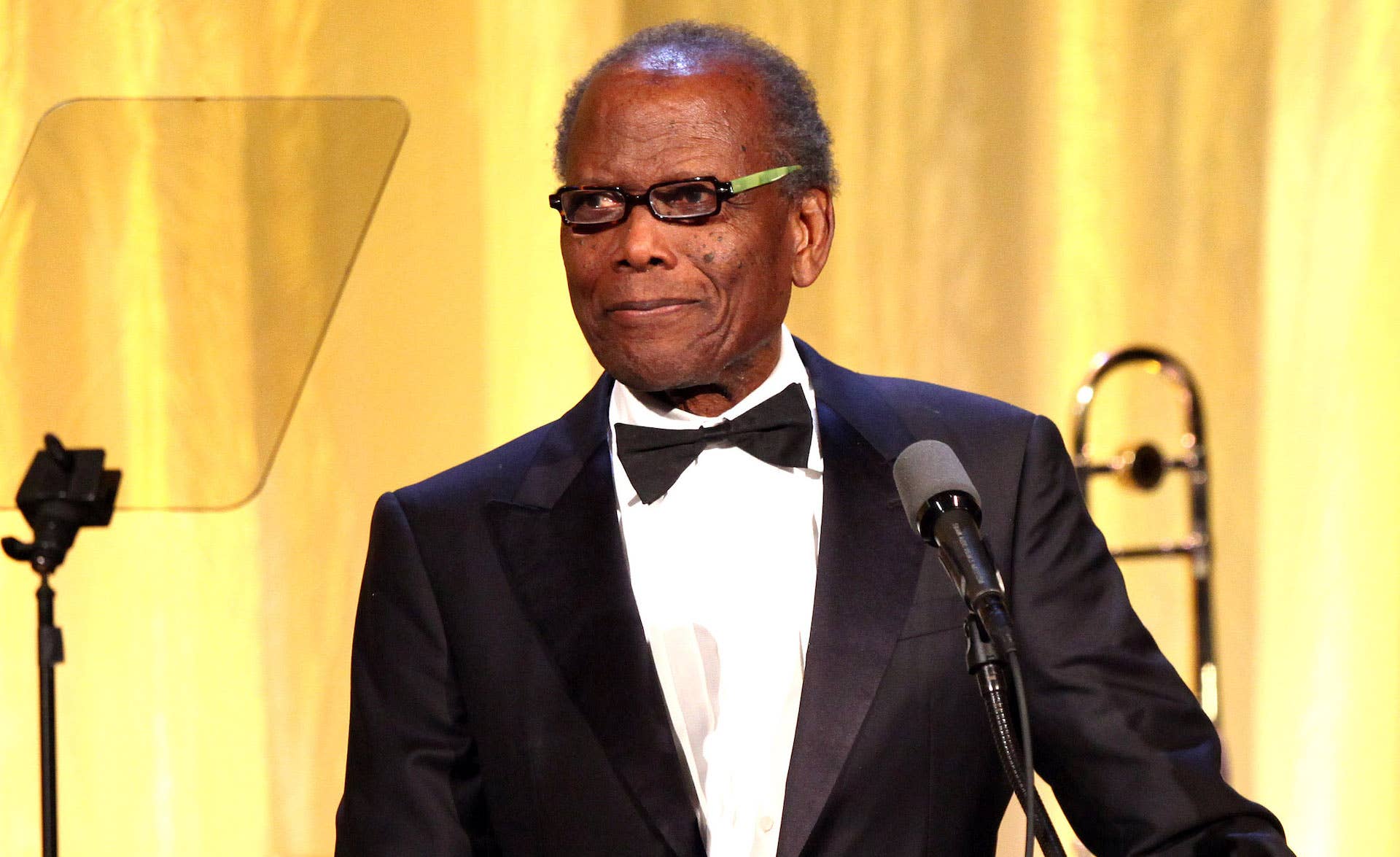 Sidney Poitier onstage in glasses