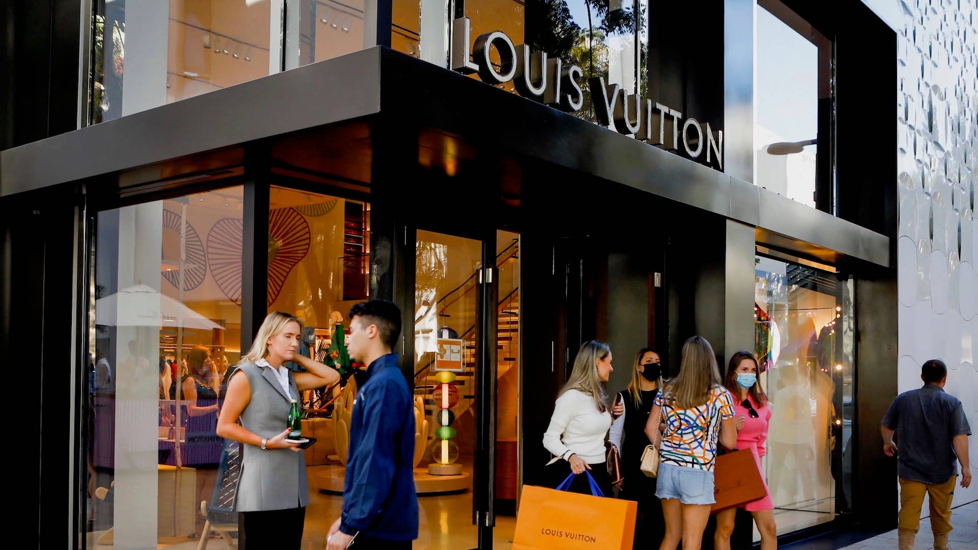 Shoppers exit the Louis Vuitton store in Miami, Florida