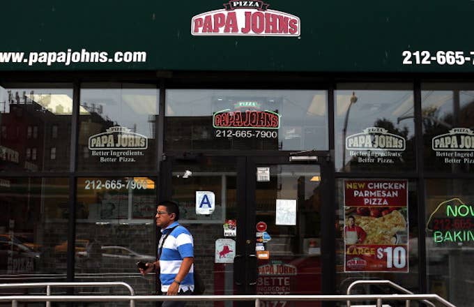 A man walks by a Papa Johns pizza restaurant