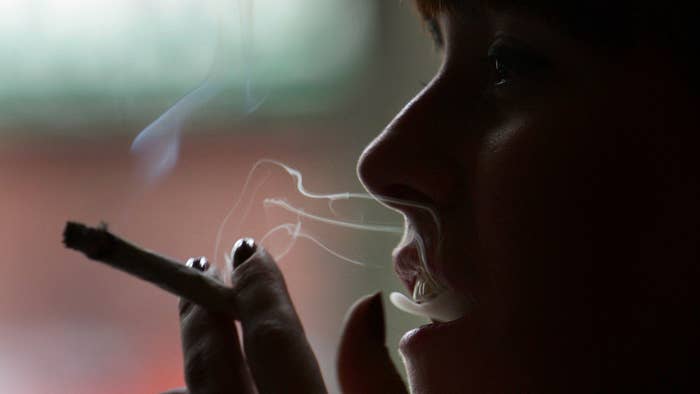 A woman smokes a cigarette of marijuana in an Amsterdam cafe.