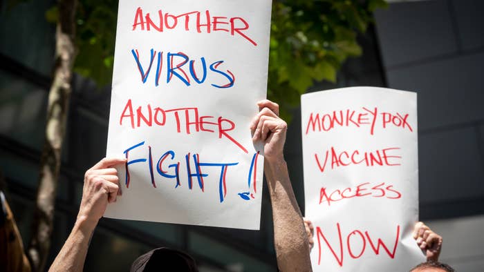 People hold signs during monkeypox rally in San Francisco.
