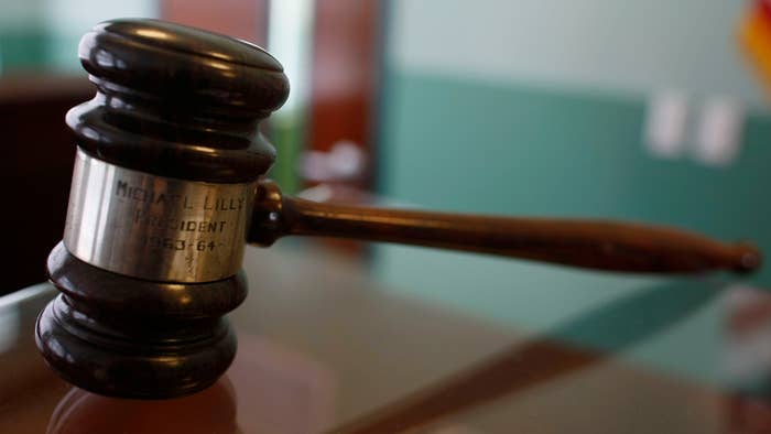 A judges gavel rests on top of a desk in the courtroom.