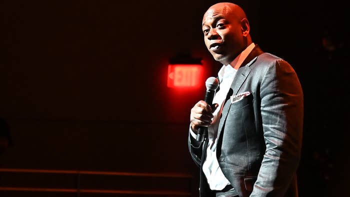 Dave Chappelle is seen holding a microphone