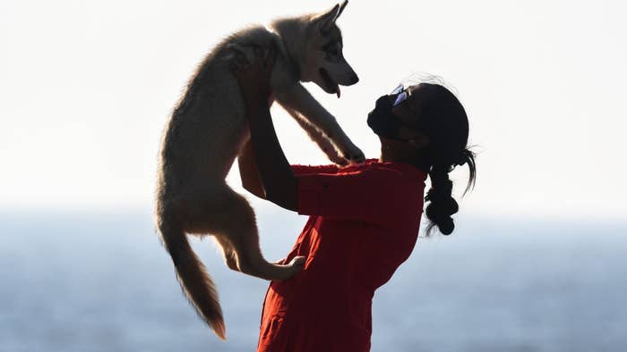 A woman holds her pet dog in India