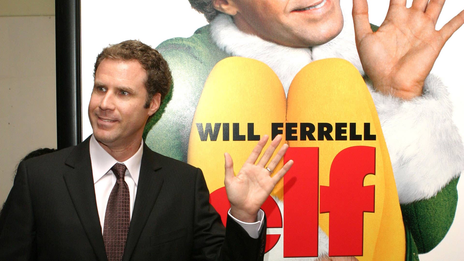 Will Ferrell poses alongside the poster for 'Elf'.