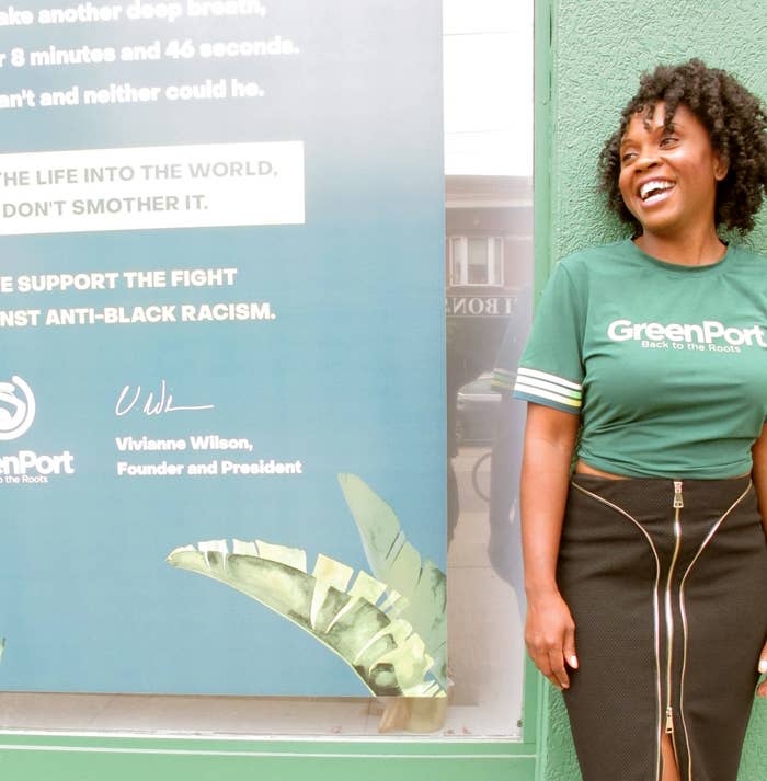 Vivianne Wilson, owner of Greenport Cannabis, standing in front of the storefront in a GreenPort shirt