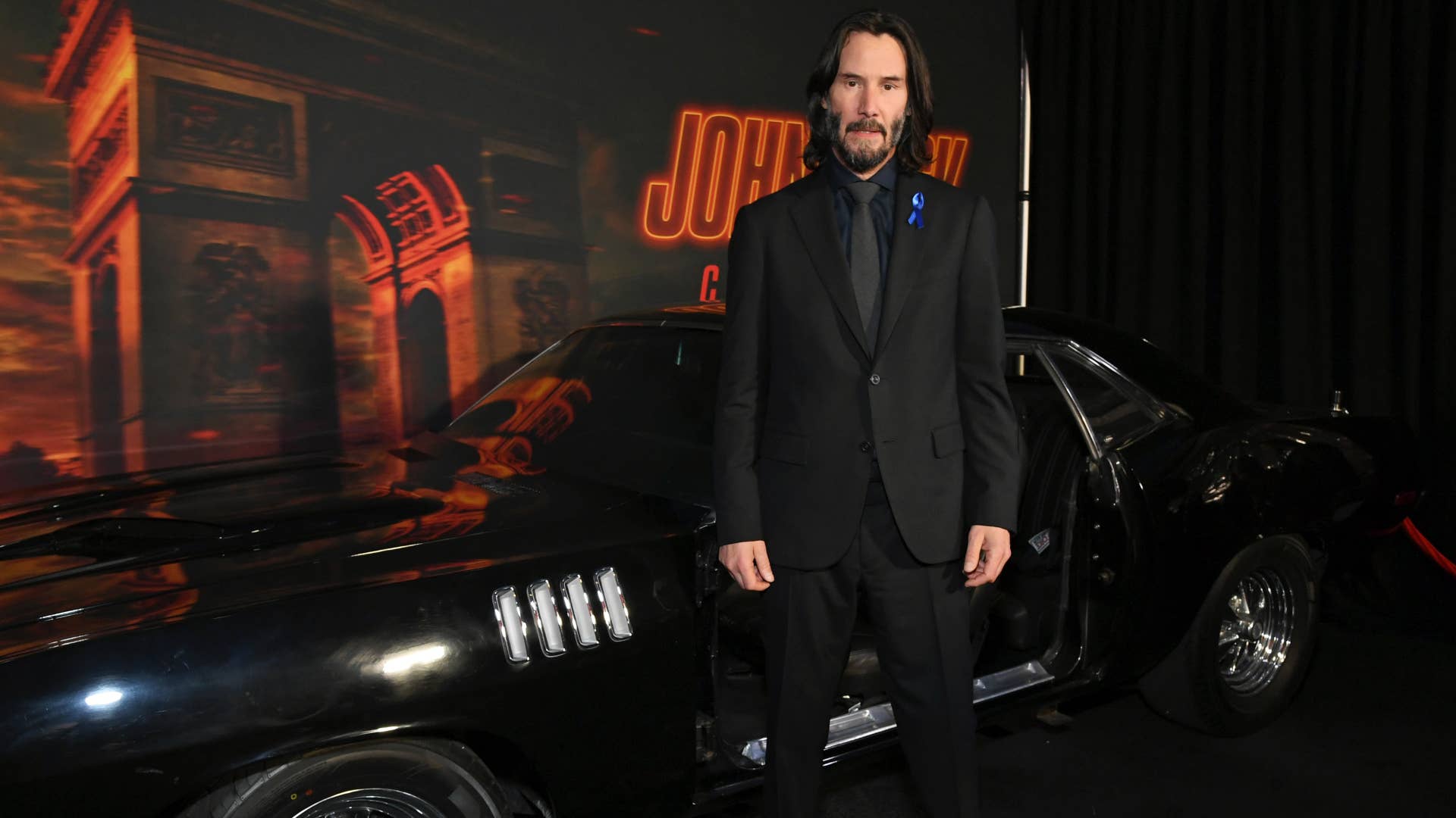 Keanu Reeves is seen standing in front of car