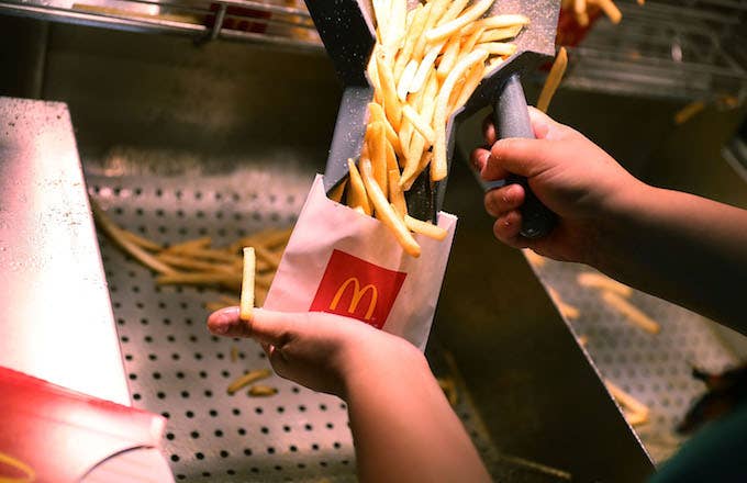 A  McDonald&#x27;s crew member preparing fries.