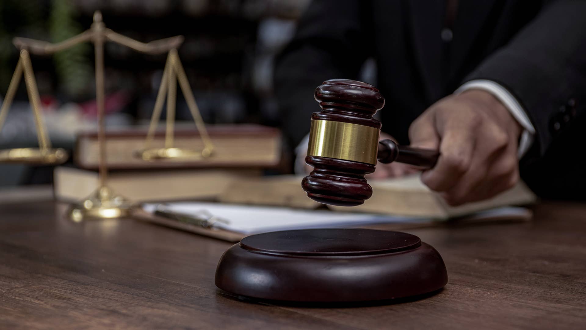 Man hand knocking a wooden judge gavel, law and auction concept.