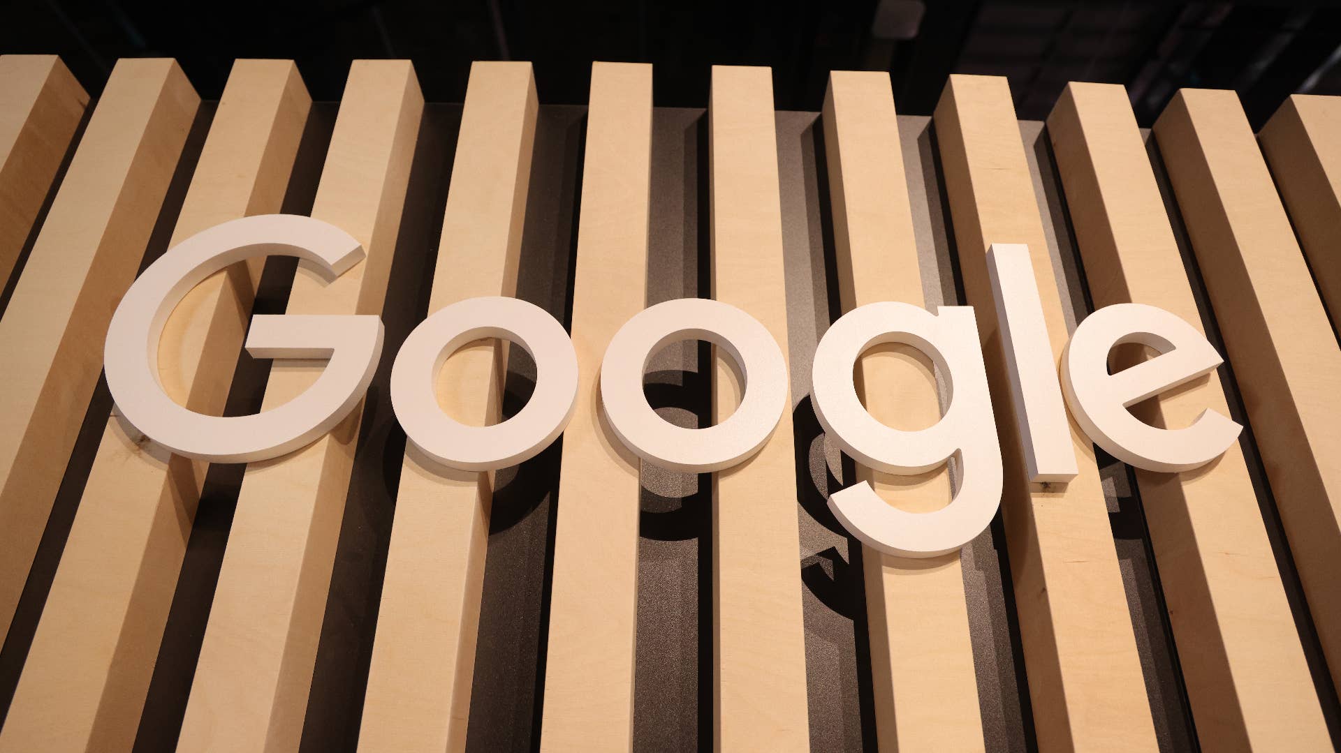 A wooden Google logo hangs at a stand.