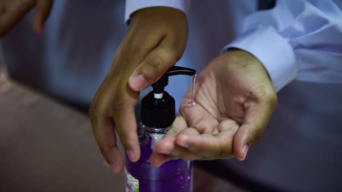 Thai student using hand sanitizer amid coronavirus pandemic.