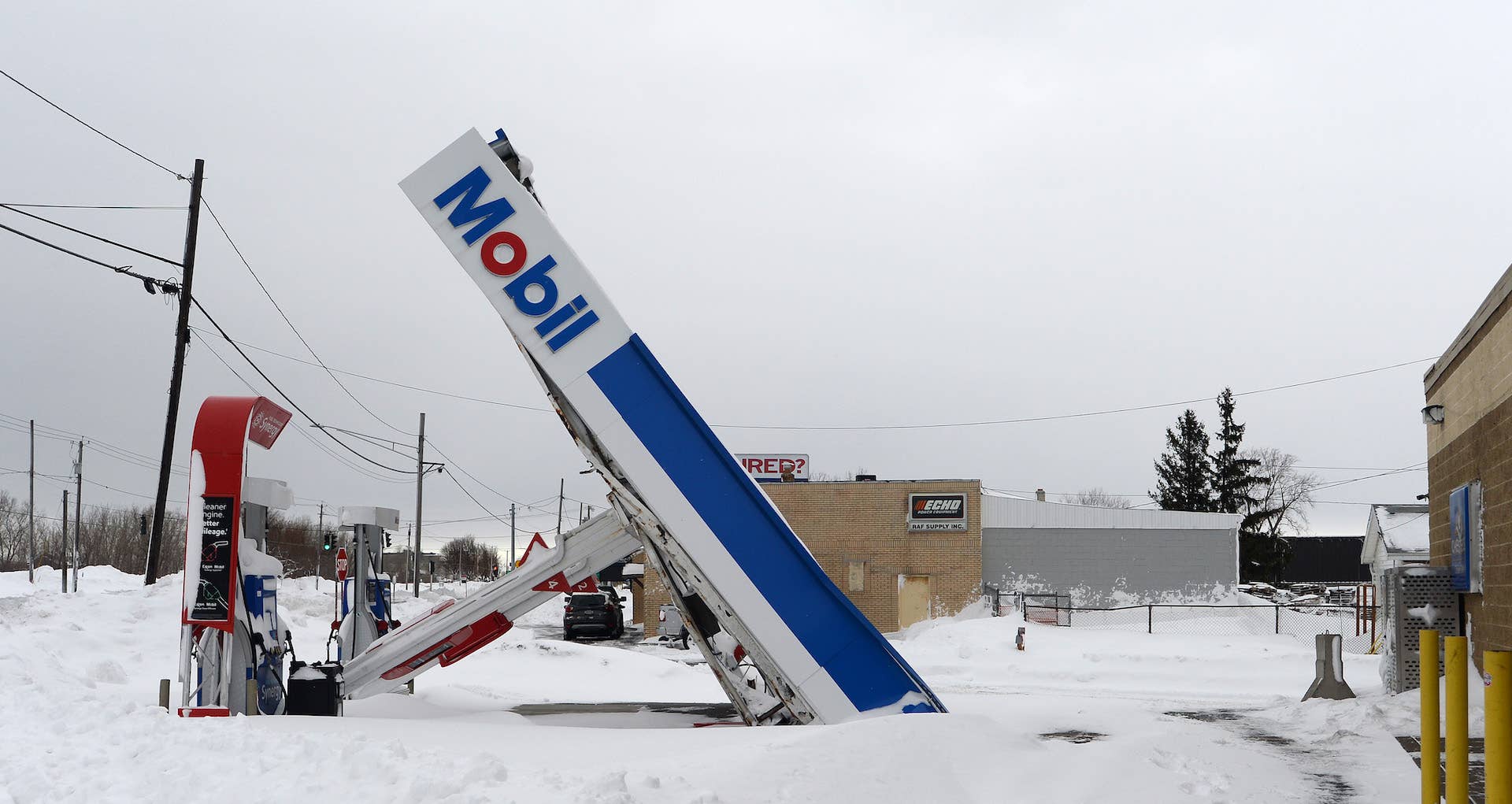 A gas station canopy lays on its side after high winds and heavy snow along Lake Shore Boulevard
