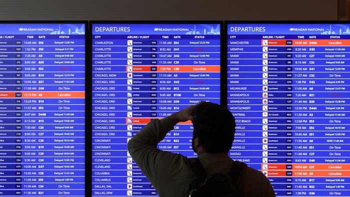 A traveler looks at a flight information board at Ronald Reagan Washington National Airport