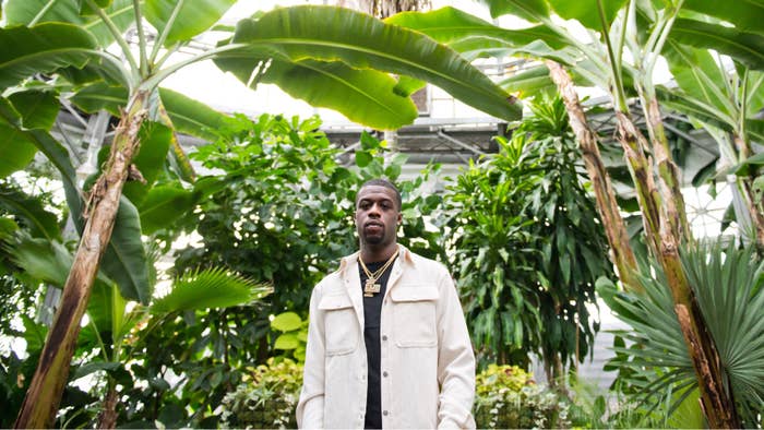 Roz wearing a white jacket, standing under palm trees