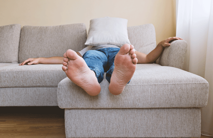 Stock photo of a man sleeping barefoot.