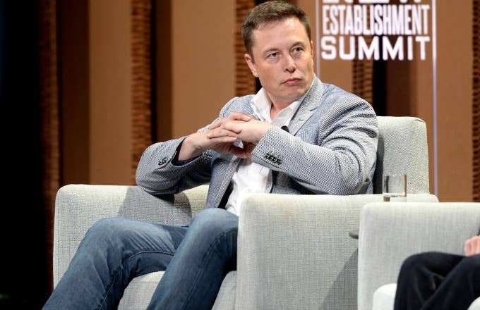 Elon Musk sits on a panel.