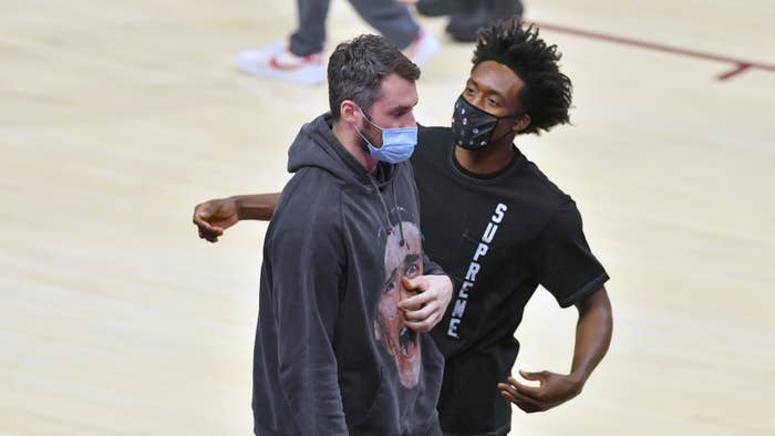 Kevin Love and Collin Sexton joke on the sidelines.