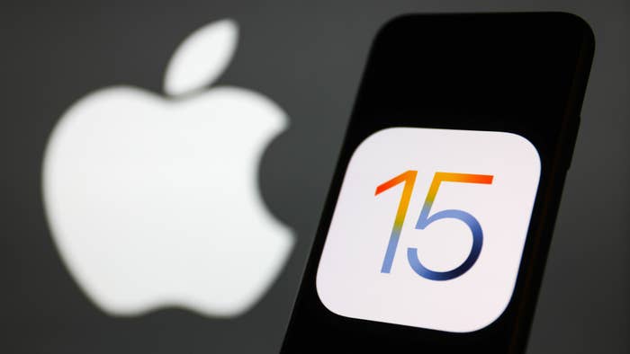 iOS 15 logo displayed on a phone screen and Apple logo in the background.