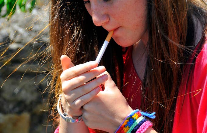Teenager lighting up a cigarette.