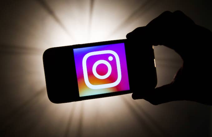 Instagram logo is seen displayed on a phone screen.
