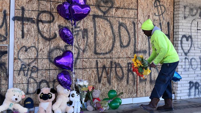 A man places flowers at the memorial for Young Dolph outside of Makeda&#x27;s Cookies bakery