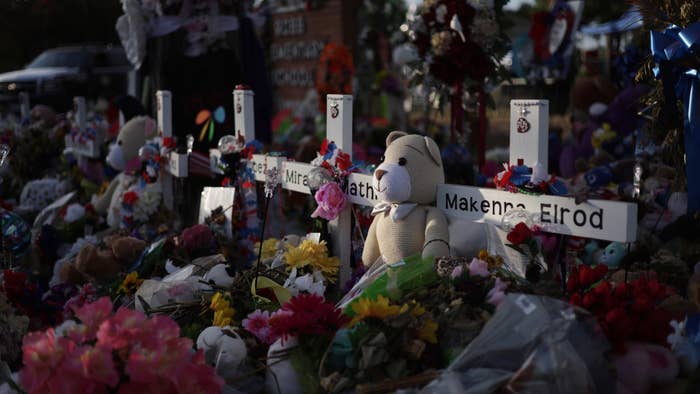 Flowers, plush toys and wooden crosses are placed at a memorial