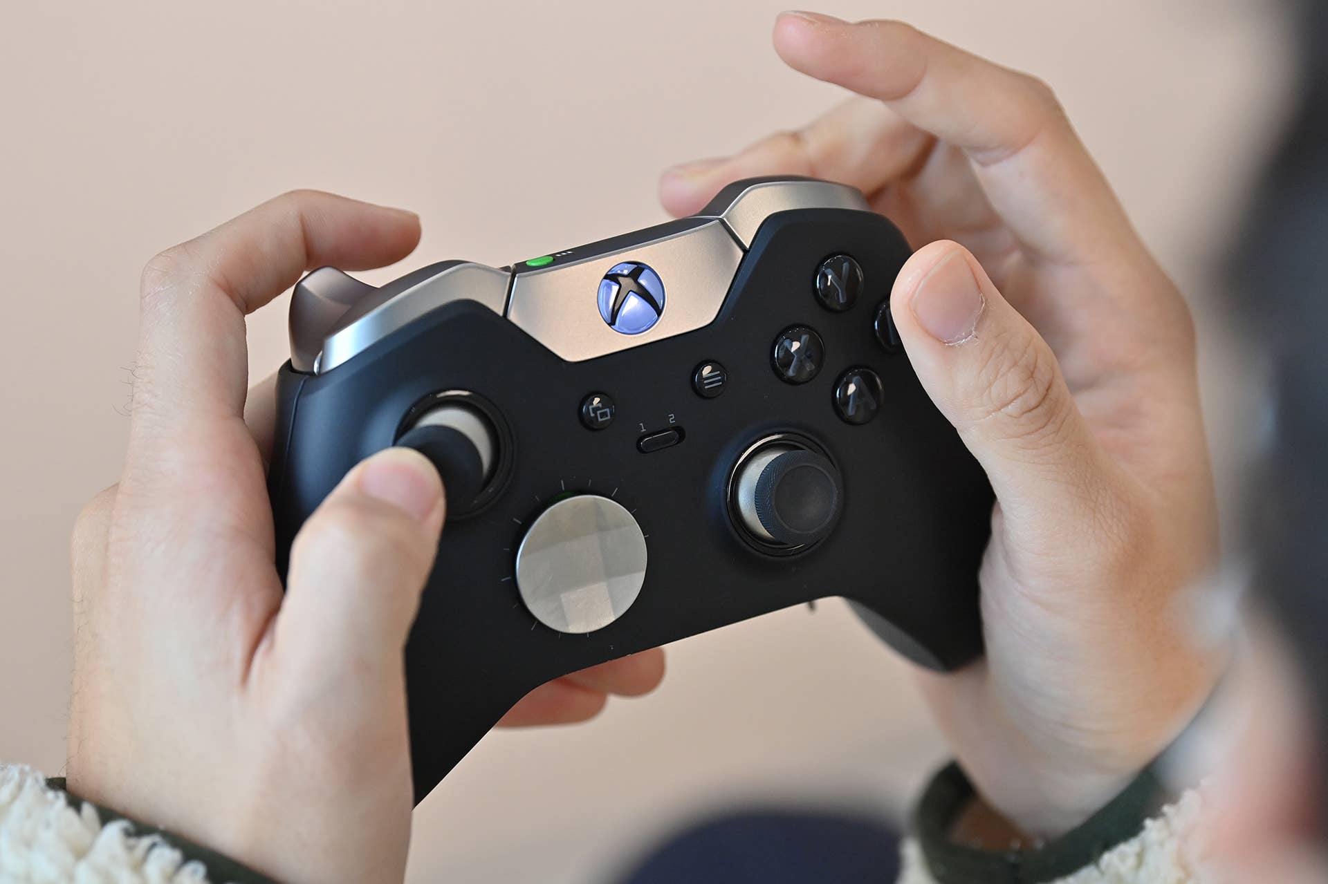 A visitor plays a game using Microsoft's Xbox controller at a flagship store of SK Telecom in Seoul