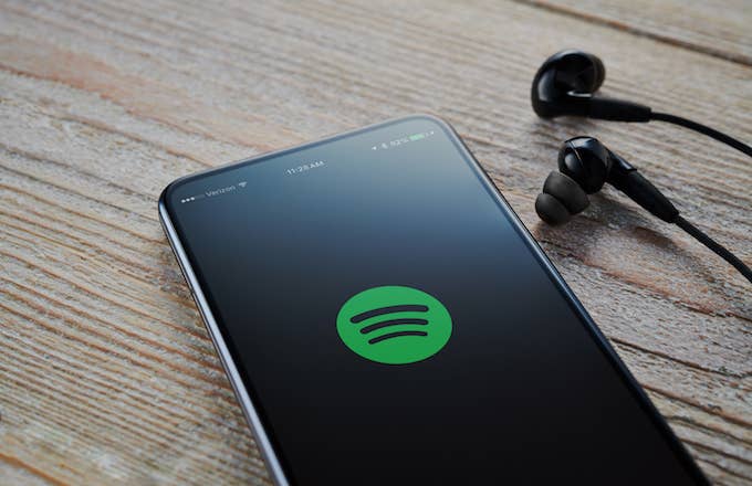 An Android smartphone with the Spotify Music logo visible on screen.