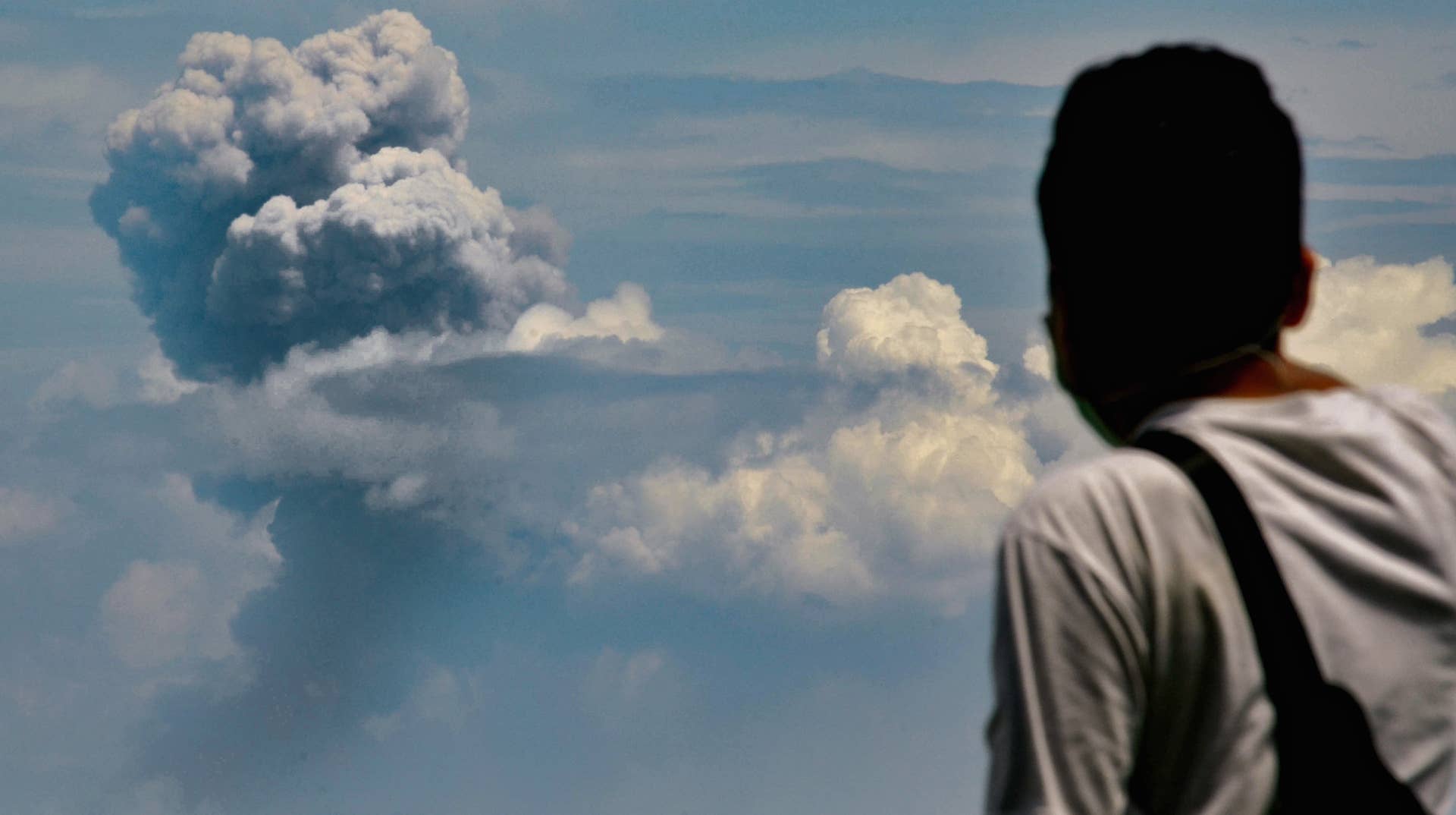 A man watches Krakatau spewing ash during an eruption