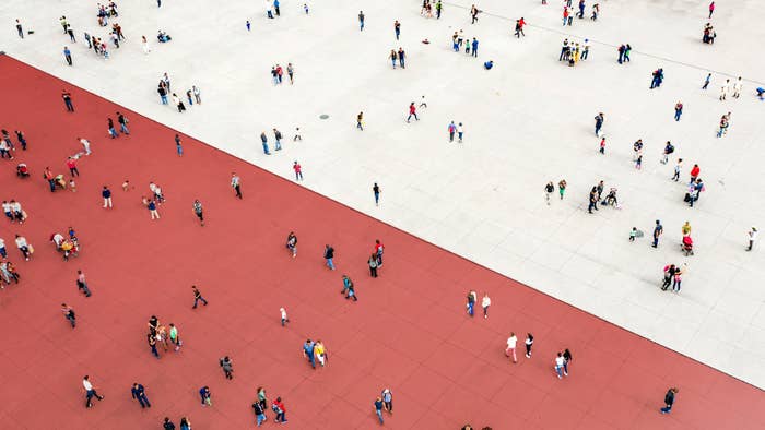 People standing on two different sides zones, one red, one white.