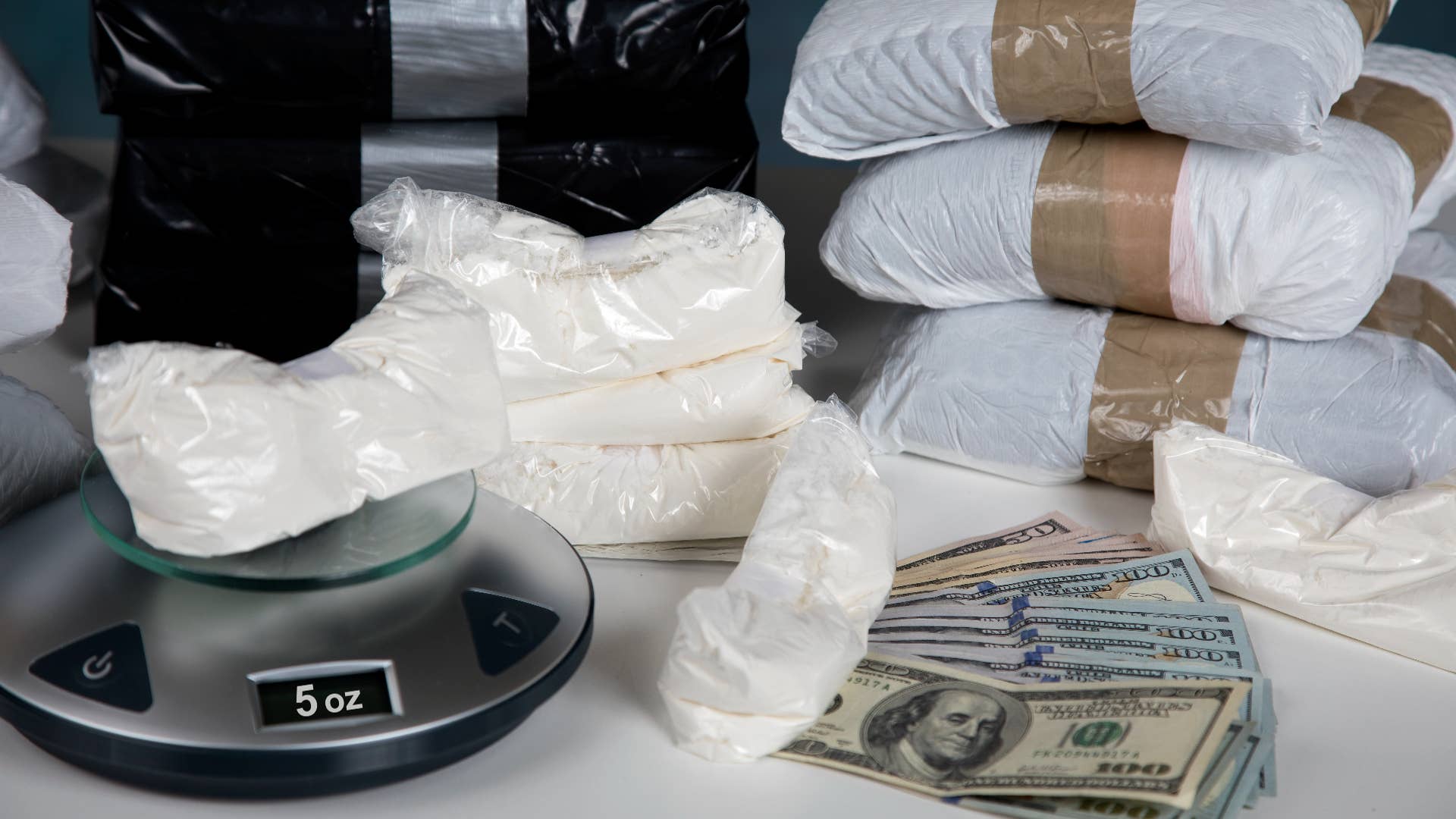 Illegal drugs on a scale with cash.