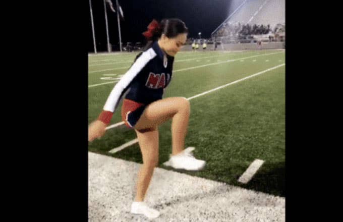 A cheerleader steps on an invisible box.