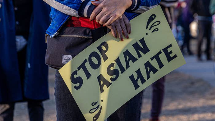 A person holds a sign during the &quot;Asian Solidarity March&quot; rally.