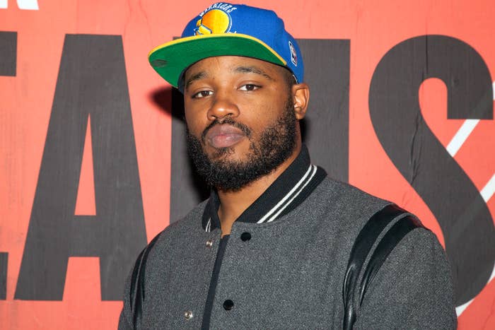 Ryan Coogler poses in front of a movie themed mural at The Guardian Project