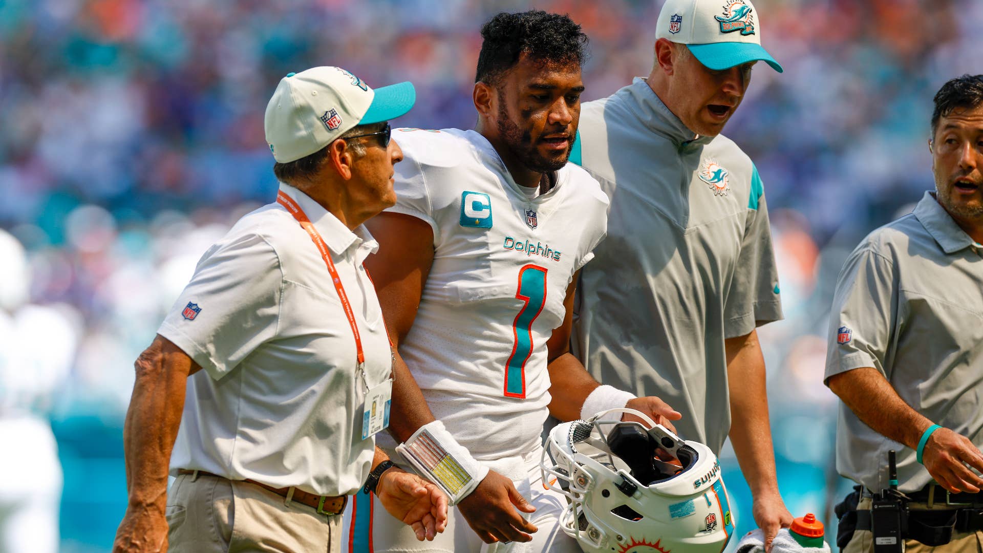Tua Tagovailoa walks off the field with trainers following a play during the game between the Buffalo Bills and the Miami Dolphins.