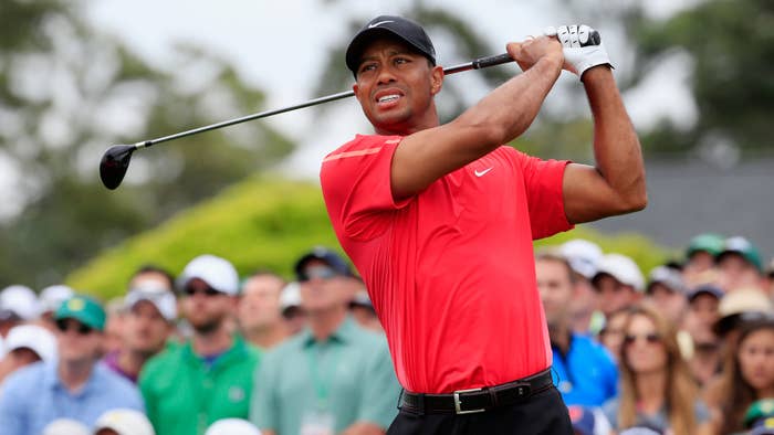 Tiger Woods watches his tee shot on the first hole of the 2015 Masters Tournament.