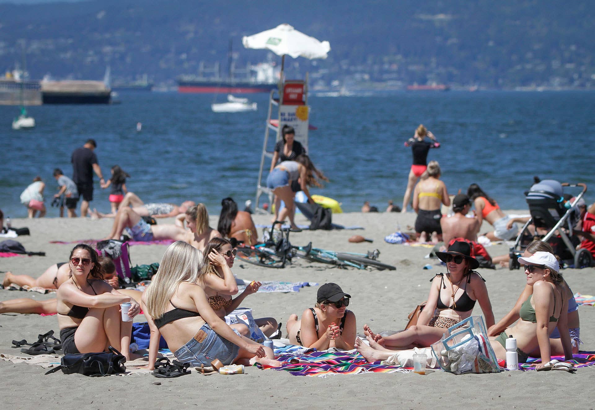 People enjoy their leisure time under the hot weather warning at Kitsilano Beach in Vancouver, Canada,